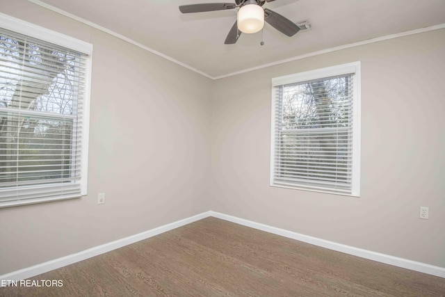 unfurnished room with ornamental molding, wood finished floors, a ceiling fan, and baseboards