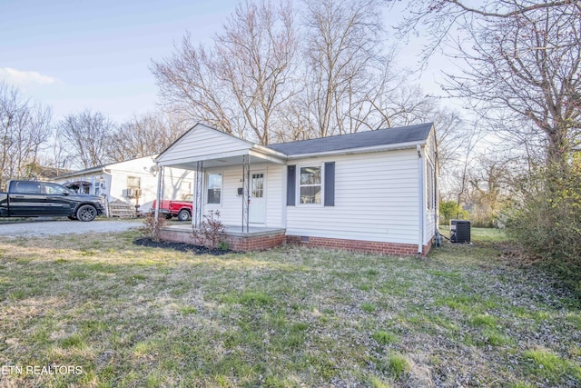 view of front of house with a shingled roof, crawl space, covered porch, central AC, and a front yard