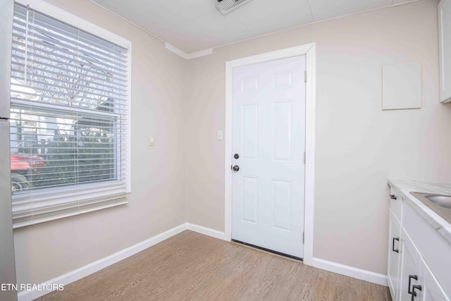 entryway with light wood-style floors, visible vents, and baseboards