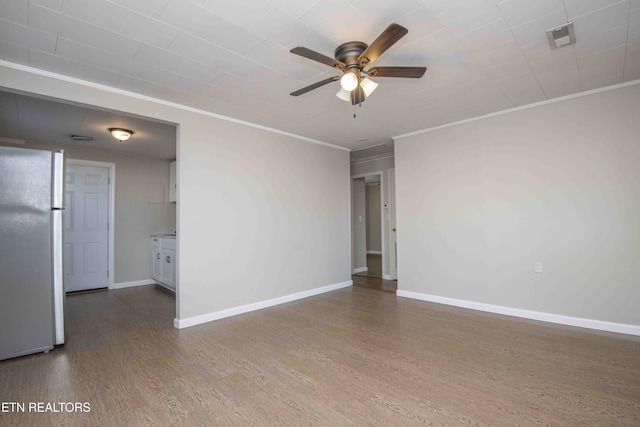 unfurnished room featuring baseboards, visible vents, ceiling fan, wood finished floors, and crown molding