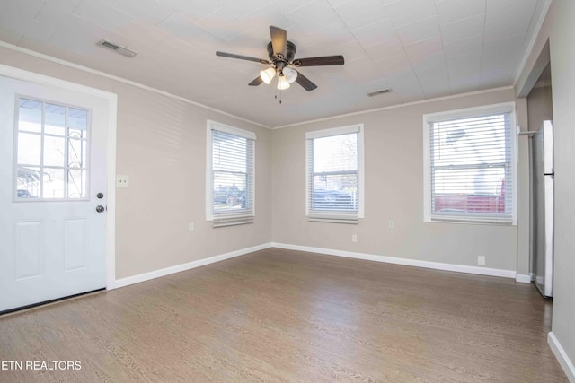 foyer featuring ornamental molding, visible vents, baseboards, and wood finished floors