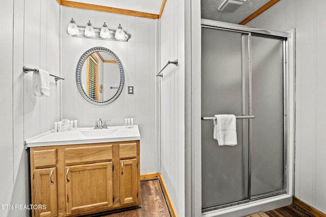 bathroom with vanity, wood finished floors, and a shower stall