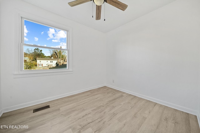 unfurnished room featuring a ceiling fan, visible vents, baseboards, and wood finished floors