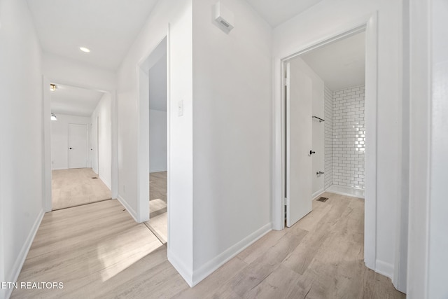 corridor featuring baseboards and light wood-style floors
