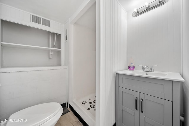 full bathroom featuring toilet, a shower stall, visible vents, and vanity