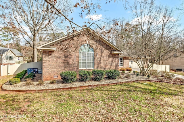 view of side of home featuring concrete driveway, crawl space, an attached garage, fence, and brick siding