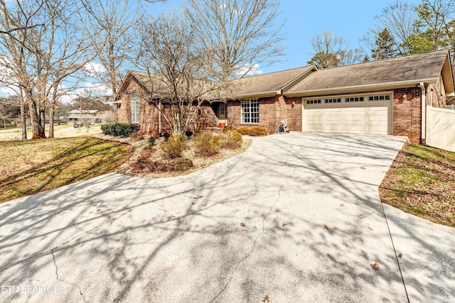 view of front of house with a garage, brick siding, and driveway