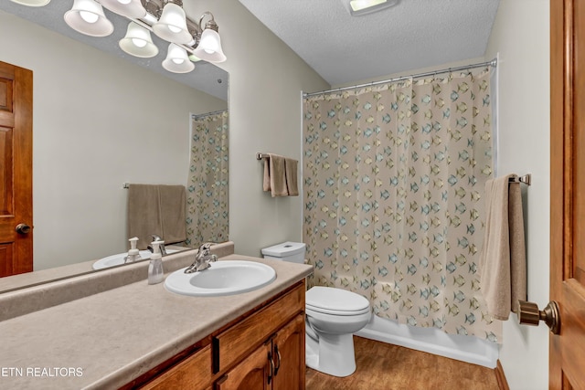 full bathroom featuring a textured ceiling, toilet, wood finished floors, vanity, and shower / bath combo with shower curtain