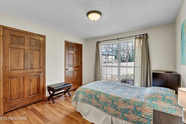 bedroom featuring light wood-type flooring and a textured ceiling