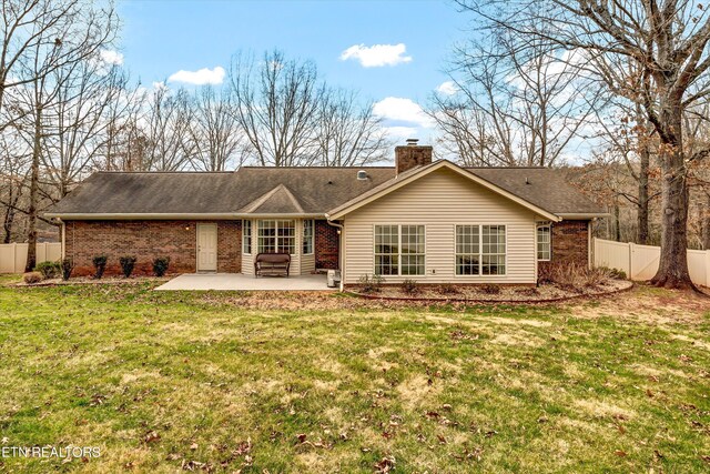 rear view of property featuring a yard, a patio area, fence, and brick siding