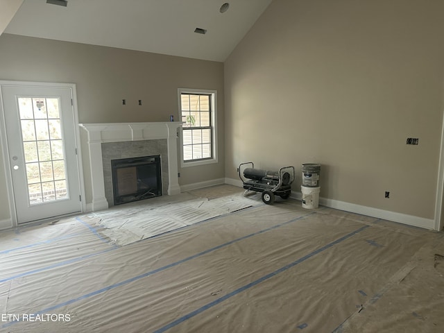 unfurnished living room featuring visible vents, a fireplace, high vaulted ceiling, and baseboards