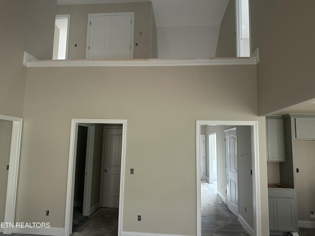 interior space with baseboards and a towering ceiling