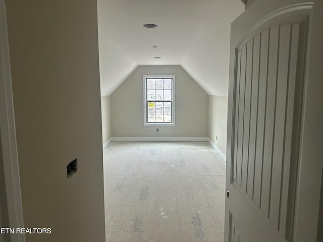 bonus room with baseboards and vaulted ceiling