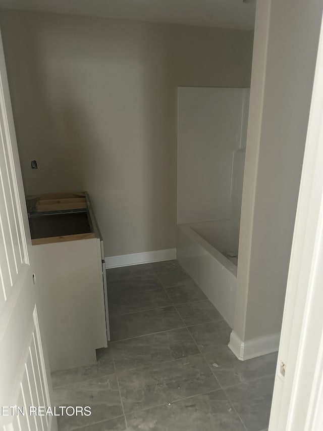 full bathroom with vanity and baseboards