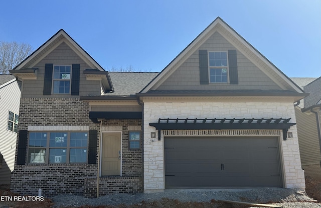 view of front of house with an attached garage and a shingled roof