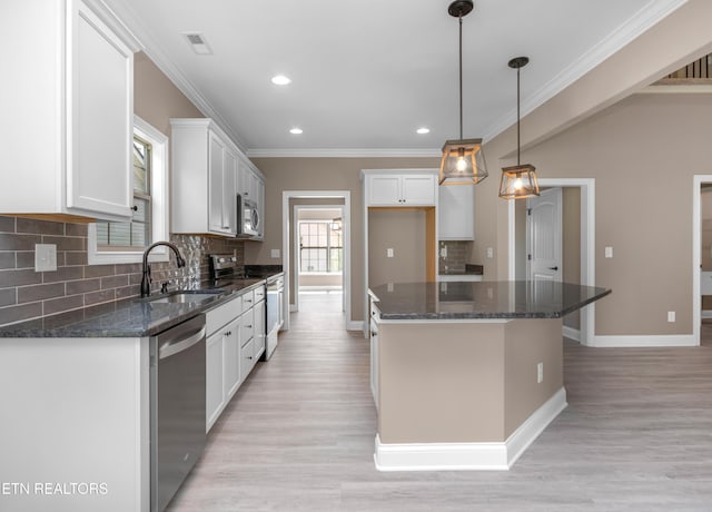 kitchen with crown molding, baseboards, a sink, visible vents, and appliances with stainless steel finishes