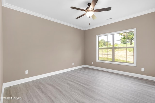 unfurnished room featuring ornamental molding, baseboards, visible vents, a ceiling fan, and wood finished floors