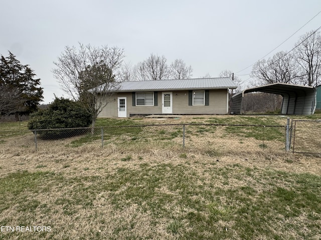 ranch-style house with a fenced front yard, a front yard, metal roof, and a detached carport