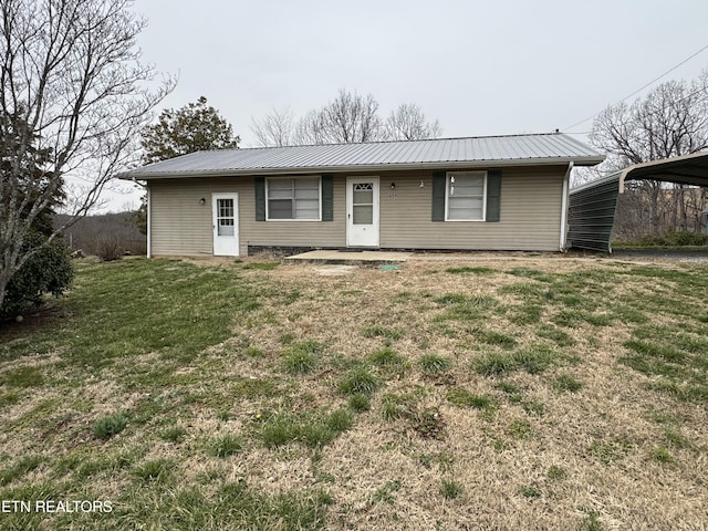 ranch-style home featuring metal roof and a front lawn