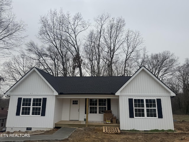 view of front of house with crawl space, board and batten siding, roof with shingles, and a porch