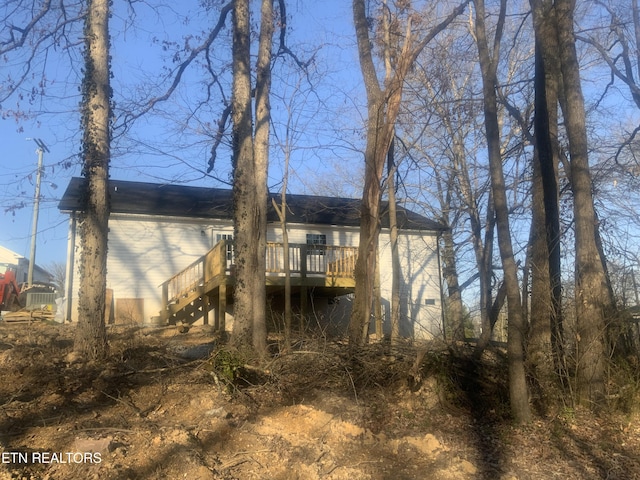 rear view of house featuring a deck and stairs