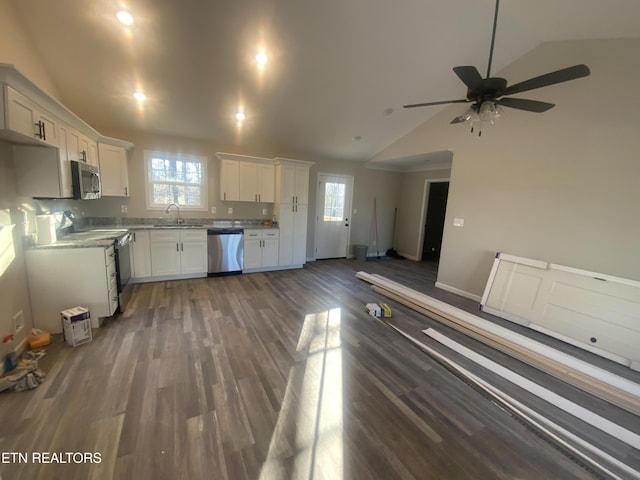 kitchen featuring a sink, dark wood finished floors, stainless steel appliances, white cabinets, and vaulted ceiling