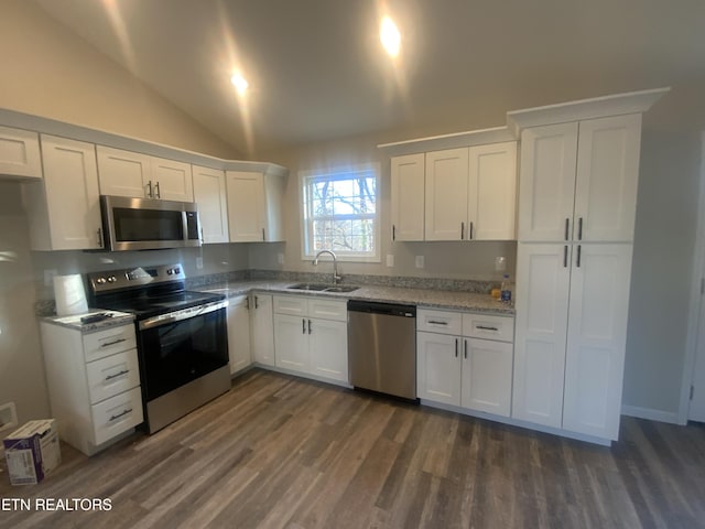 kitchen featuring a sink, dark wood finished floors, white cabinetry, stainless steel appliances, and vaulted ceiling