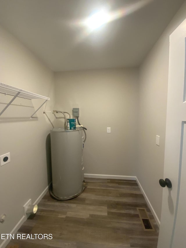 utility room featuring visible vents and electric water heater