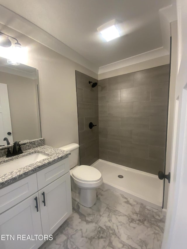 full bathroom with vanity, toilet, marble finish floor, and tiled shower