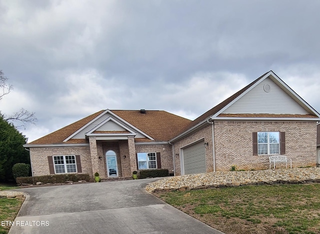 view of front of home featuring driveway, brick siding, and an attached garage