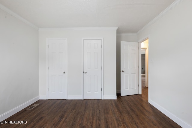 unfurnished bedroom featuring crown molding, wood finished floors, visible vents, and baseboards