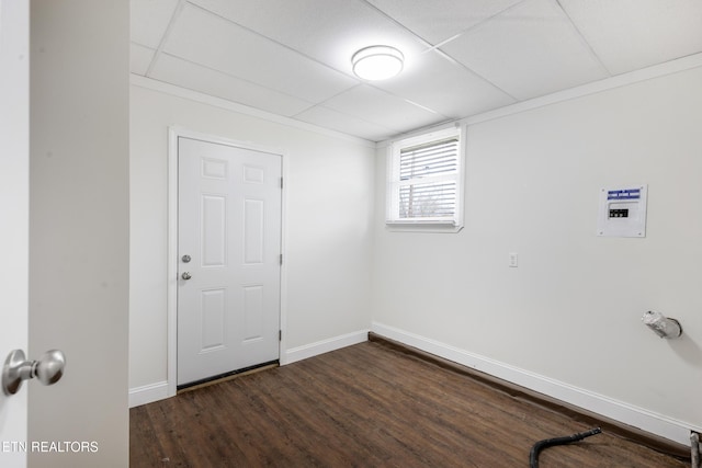 below grade area featuring a paneled ceiling, dark wood finished floors, and baseboards