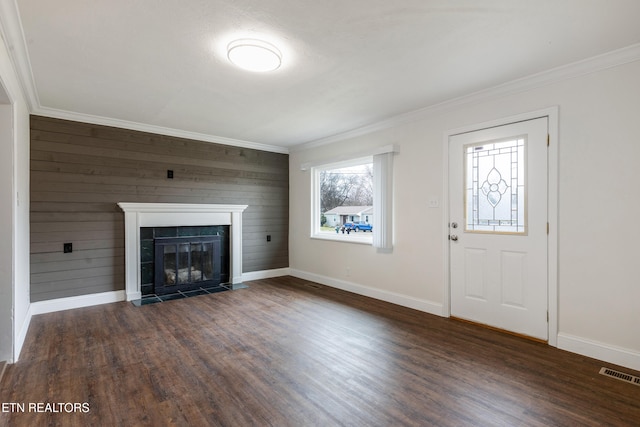 unfurnished living room with dark wood-style flooring, a tile fireplace, visible vents, and baseboards