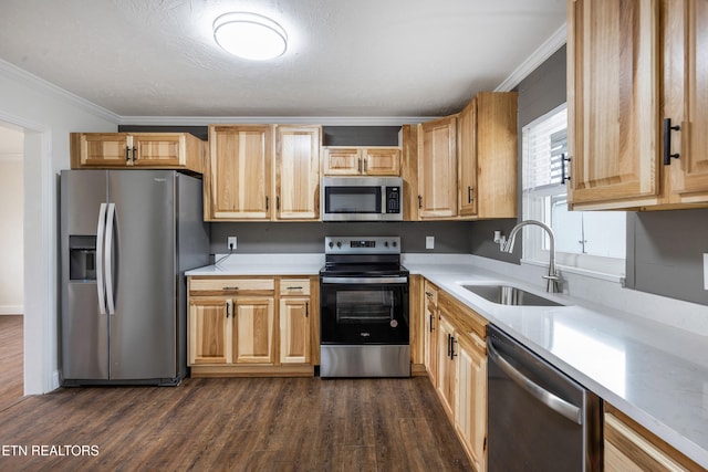 kitchen featuring ornamental molding, dark wood-type flooring, stainless steel appliances, light countertops, and a sink