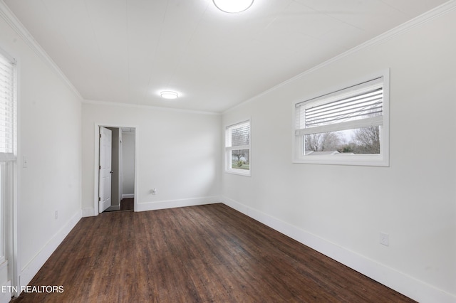 unfurnished room featuring dark wood-style floors, baseboards, and ornamental molding