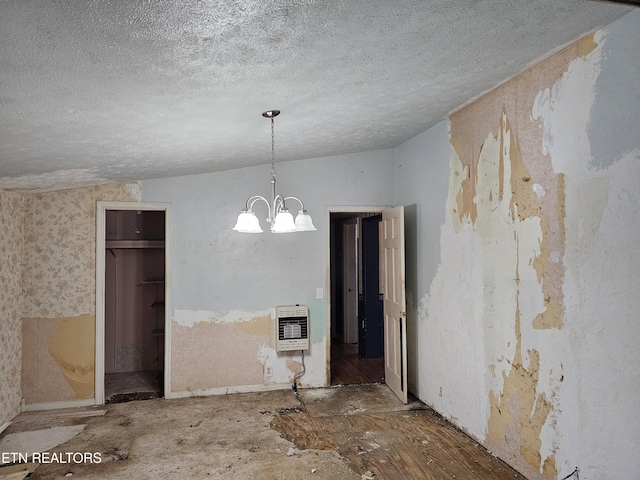 unfurnished dining area with vaulted ceiling, a textured ceiling, a chandelier, and heating unit