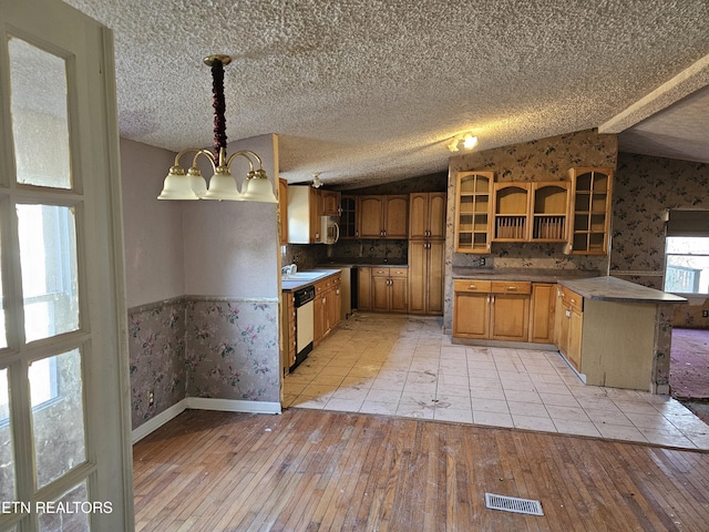 kitchen with lofted ceiling, light wood-style floors, white dishwasher, a peninsula, and wallpapered walls