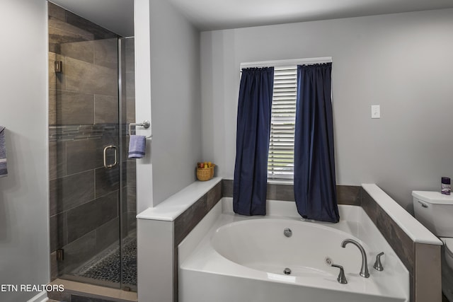 full bath with a healthy amount of sunlight, a garden tub, and toilet