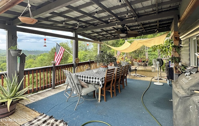 view of patio with ceiling fan, outdoor dining space, and a wooden deck