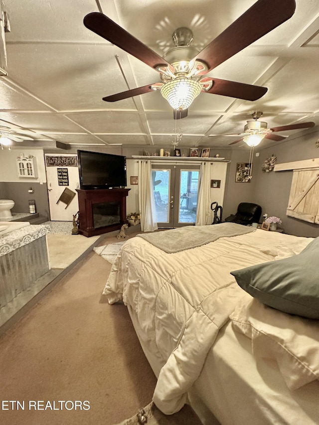 bedroom with a fireplace, coffered ceiling, and french doors