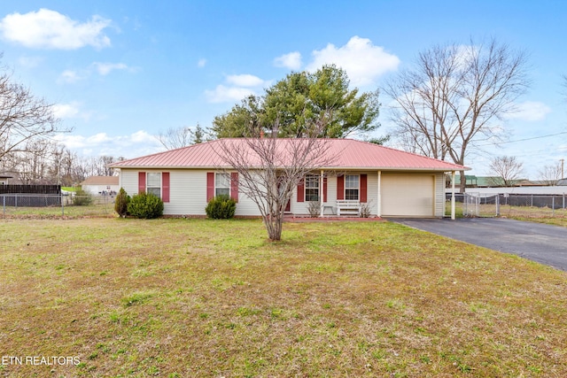 ranch-style home featuring driveway, metal roof, a garage, and fence