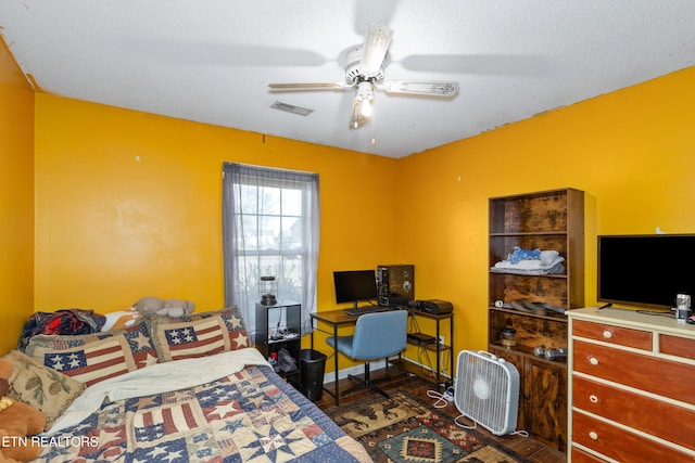 bedroom featuring visible vents, baseboards, dark wood finished floors, and a ceiling fan