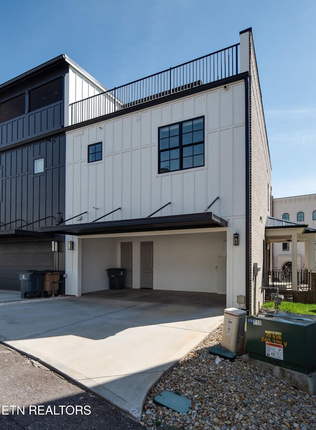 view of front facade with board and batten siding and concrete driveway