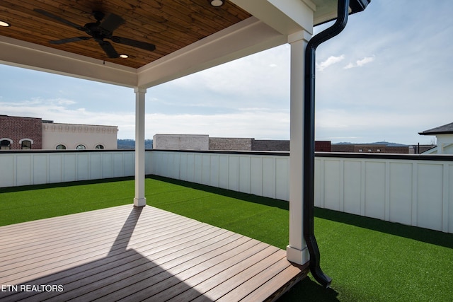 wooden deck with a fenced backyard, ceiling fan, and a yard