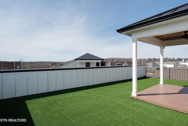 view of yard featuring fence, a ceiling fan, and a wooden deck