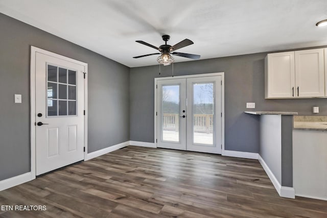 entryway with dark wood-type flooring, french doors, ceiling fan, and baseboards