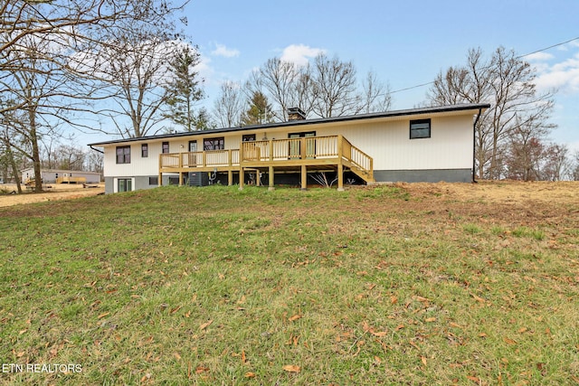 rear view of house featuring a lawn and a wooden deck