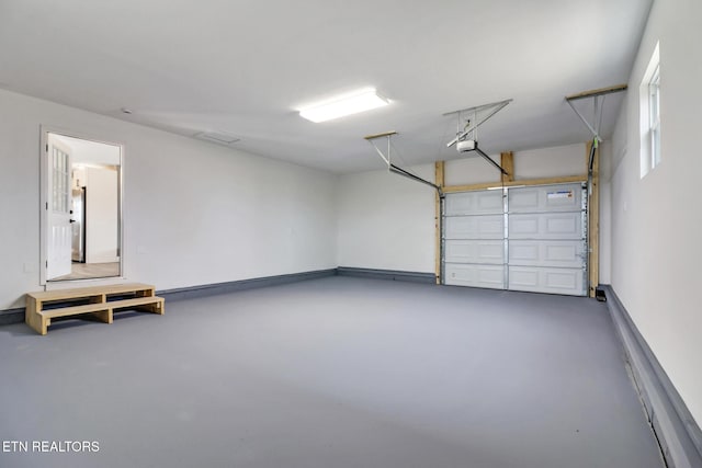 garage with baseboards and a garage door opener