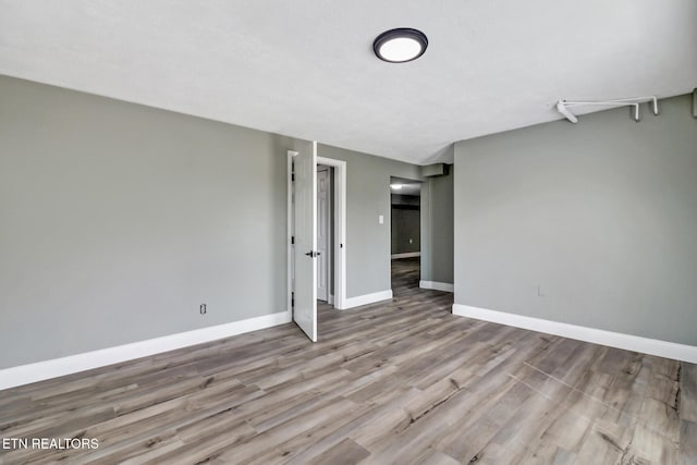 unfurnished room with baseboards and wood finished floors