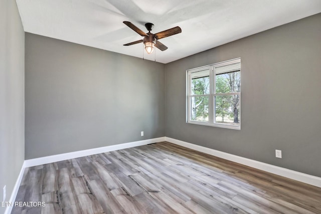 spare room featuring ceiling fan, wood finished floors, and baseboards